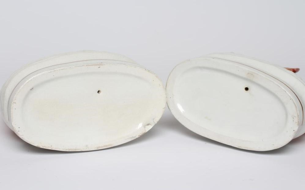 A PAIR OF VICTORIAN STAFFORDSHIRE POTTERY GREYHOUNDS modelled seated with free-standing fore-legs Image