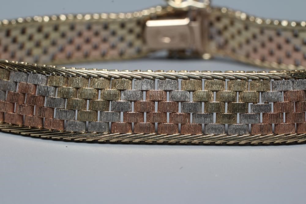 A TRI-COLOUR 9CT GOLD BRACELET the brick links with rope twist borders, slide clasp, London 1987, Image