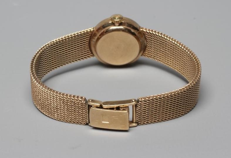 A LADY'S 9CT GOLD TISSOT WRISTWATCH, the champagne dial with applied metal batons, the unnumbered Image