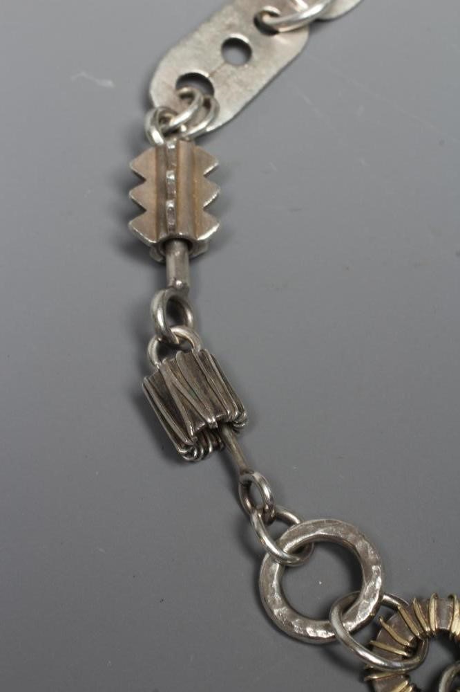 A SILVER NECKLACE BY ADELE TAYLOR, the plain circular links hung with cast 'found' objects, Image