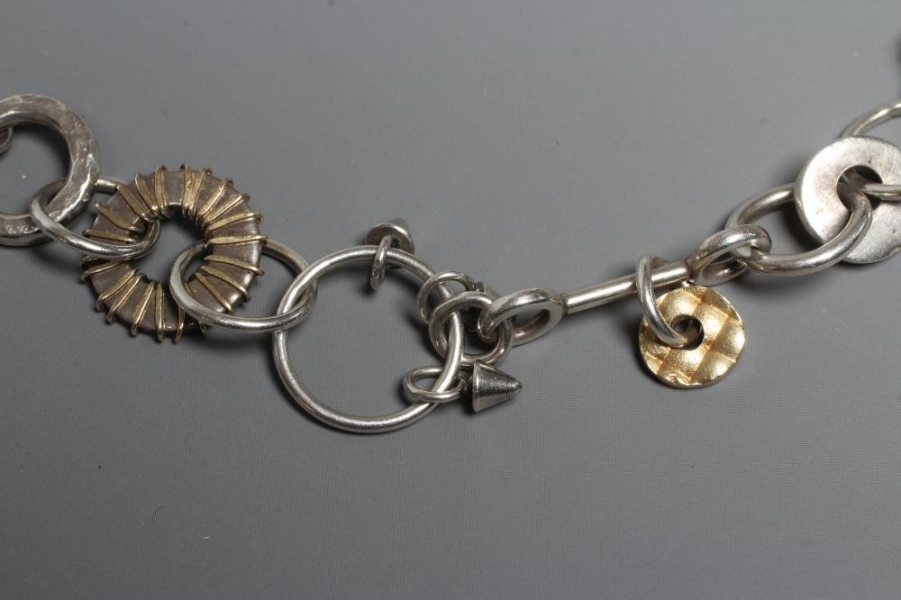 A SILVER NECKLACE BY ADELE TAYLOR, the plain circular links hung with cast 'found' objects, Image