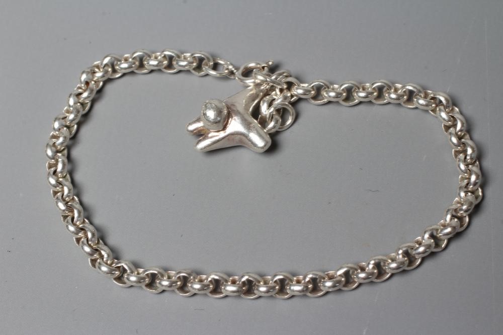 LEONARD AND ANNE EDGER- a silver pendant cast as two stylised figures suspended from a Sterling Image