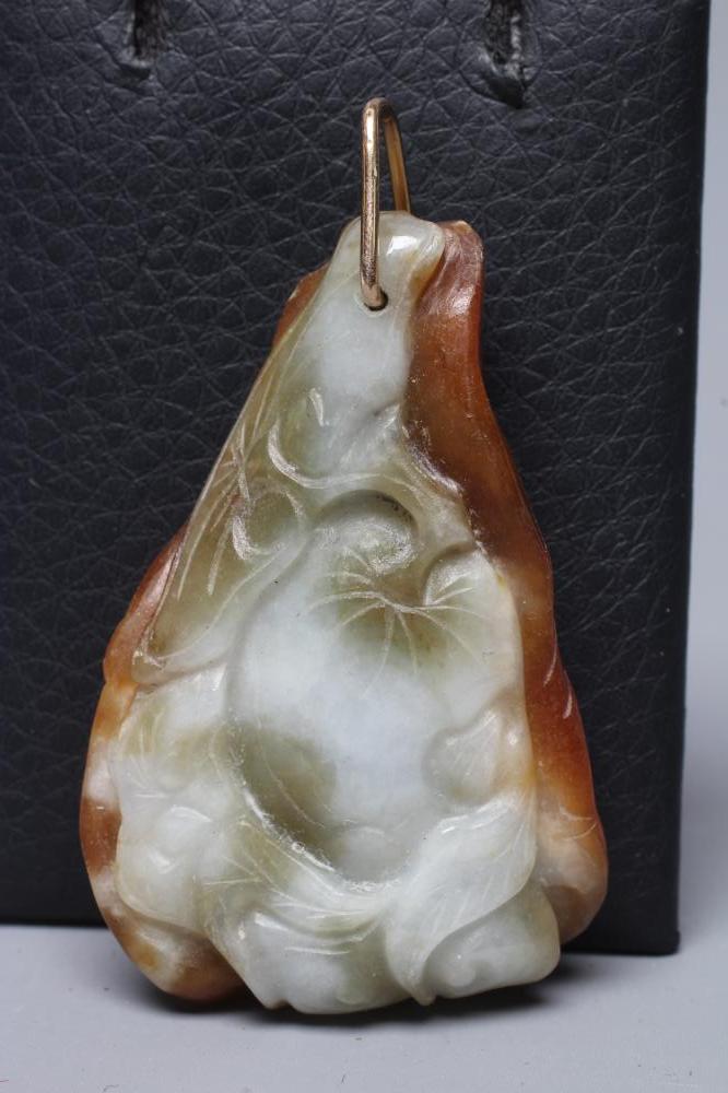 A CHINESE JADE PENDANT, one side carved as a hare (?) beside a flower, the other with a persimmon, Image