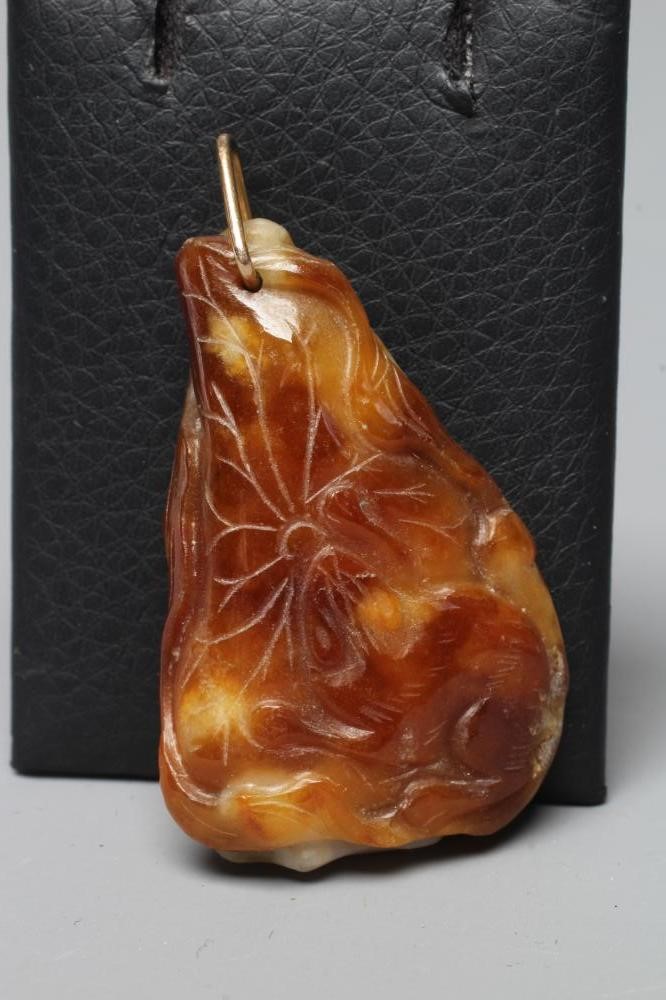 A CHINESE JADE PENDANT, one side carved as a hare (?) beside a flower, the other with a persimmon, Image
