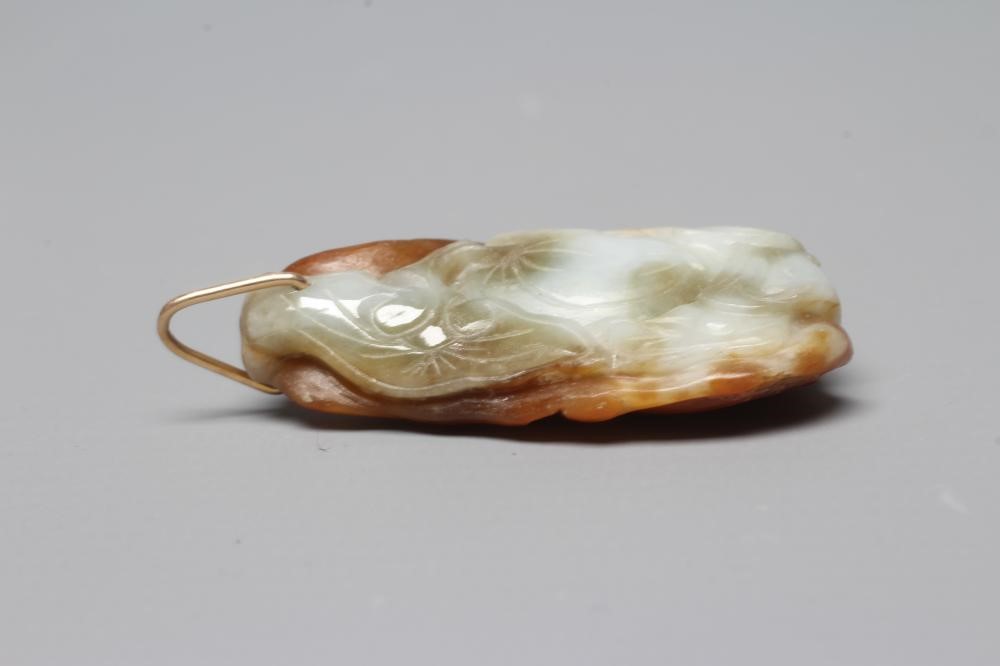 A CHINESE JADE PENDANT, one side carved as a hare (?) beside a flower, the other with a persimmon, Image