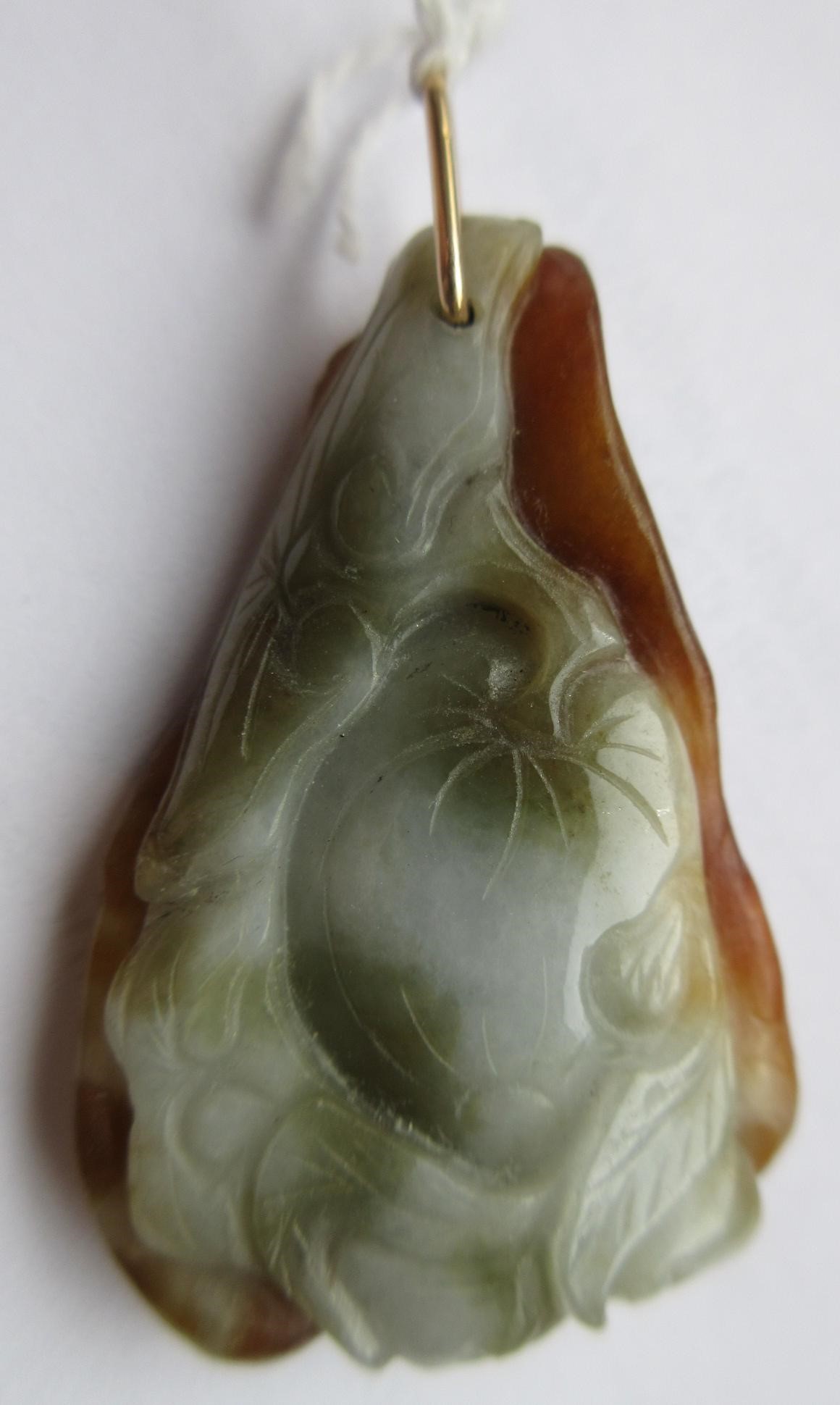 A CHINESE JADE PENDANT, one side carved as a hare (?) beside a flower, the other with a persimmon, Image