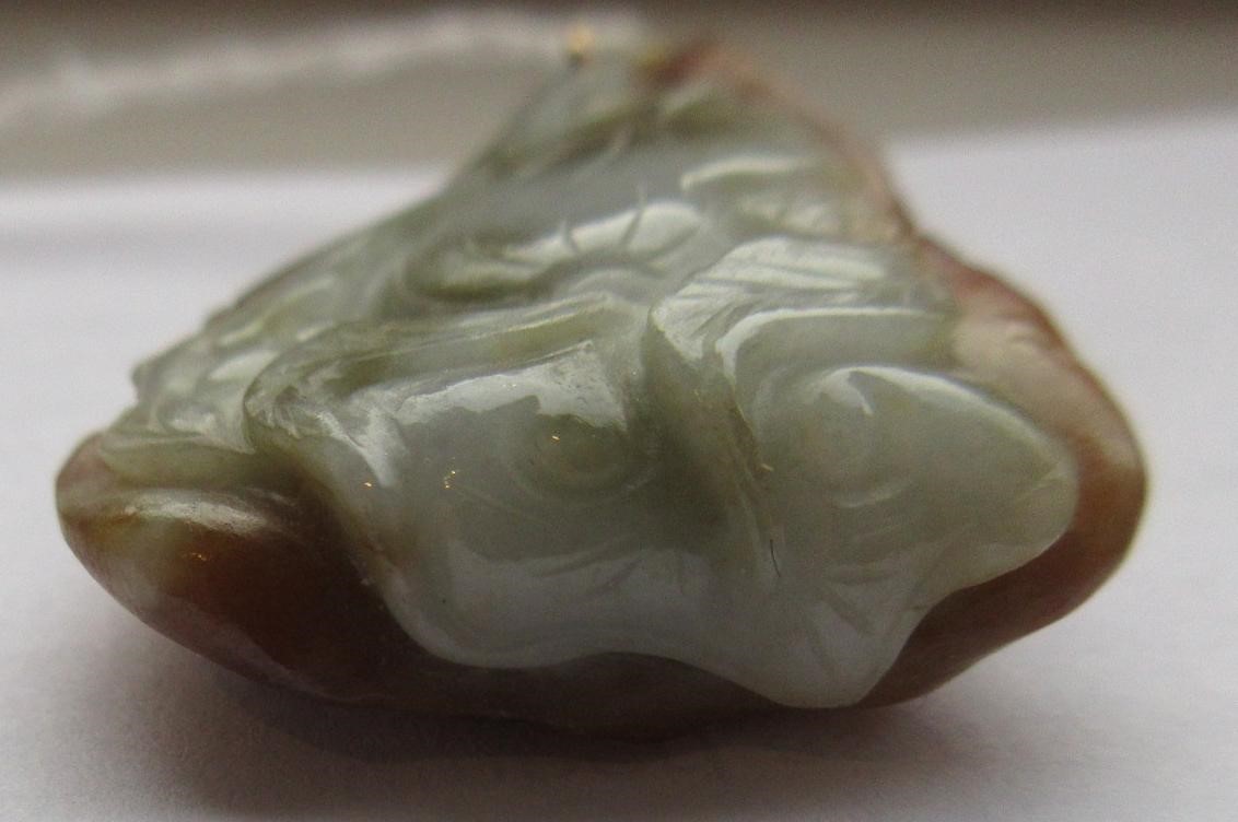 A CHINESE JADE PENDANT, one side carved as a hare (?) beside a flower, the other with a persimmon, Image