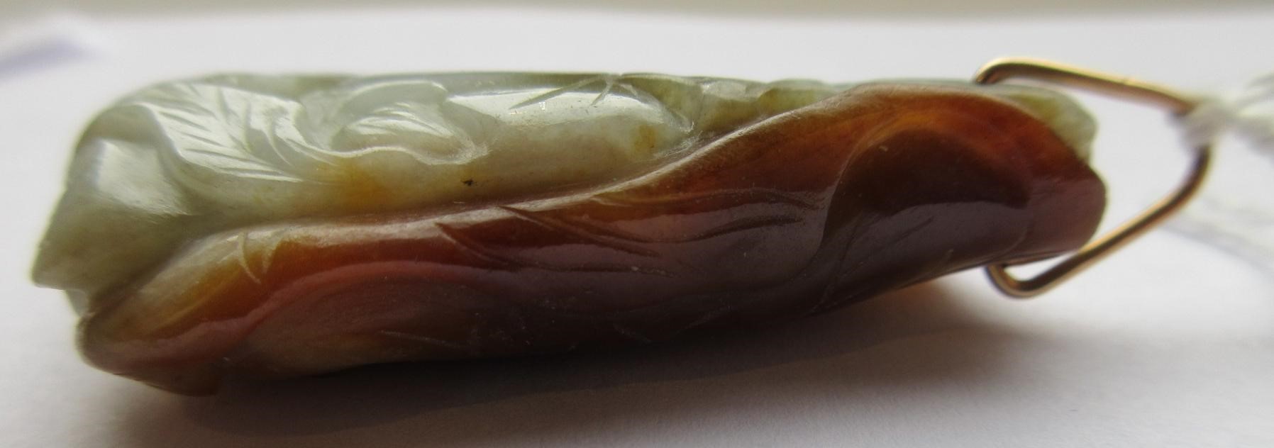 A CHINESE JADE PENDANT, one side carved as a hare (?) beside a flower, the other with a persimmon, Image