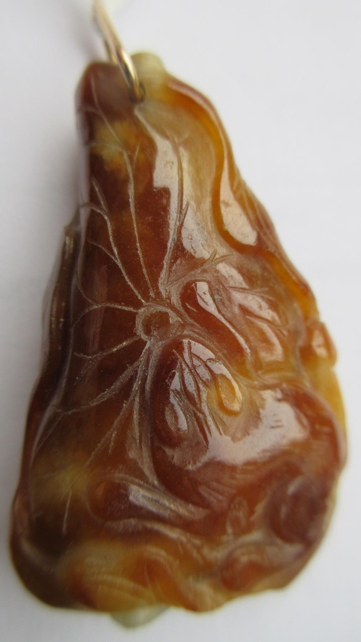 A CHINESE JADE PENDANT, one side carved as a hare (?) beside a flower, the other with a persimmon, Image