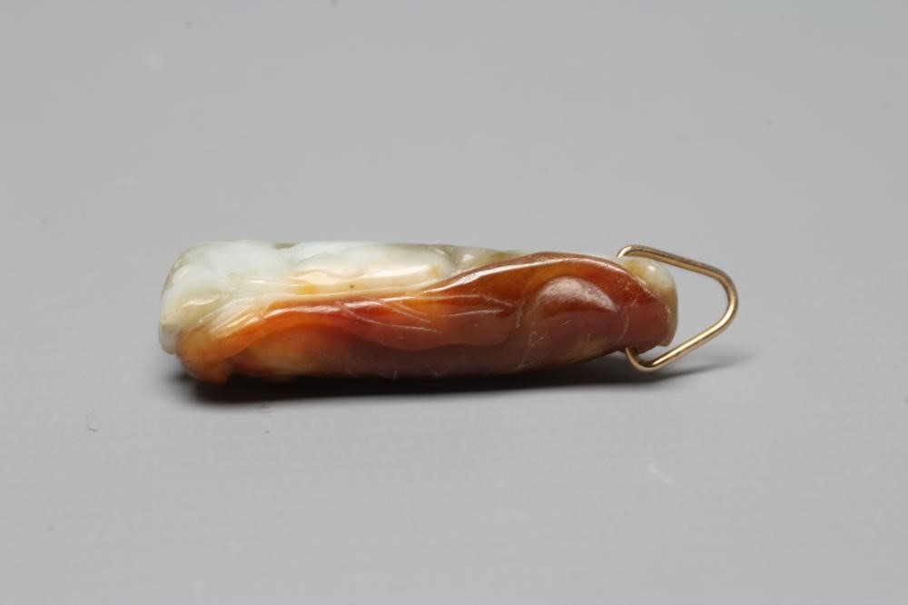 A CHINESE JADE PENDANT, one side carved as a hare (?) beside a flower, the other with a persimmon, Image