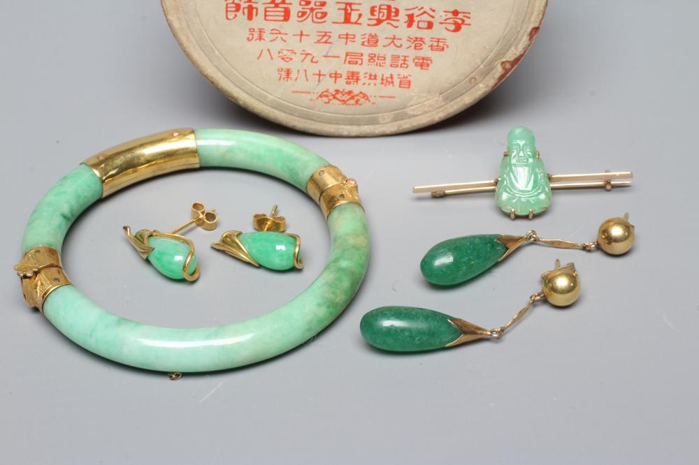 A CHINESE POLISHED JADE STIFF HINGED BANGLE of cylindrical form the chased mounts stamped 14 Image