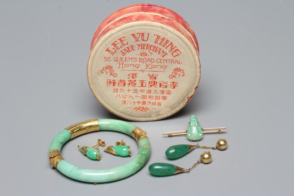 A CHINESE POLISHED JADE STIFF HINGED BANGLE of cylindrical form the chased mounts stamped 14 Image