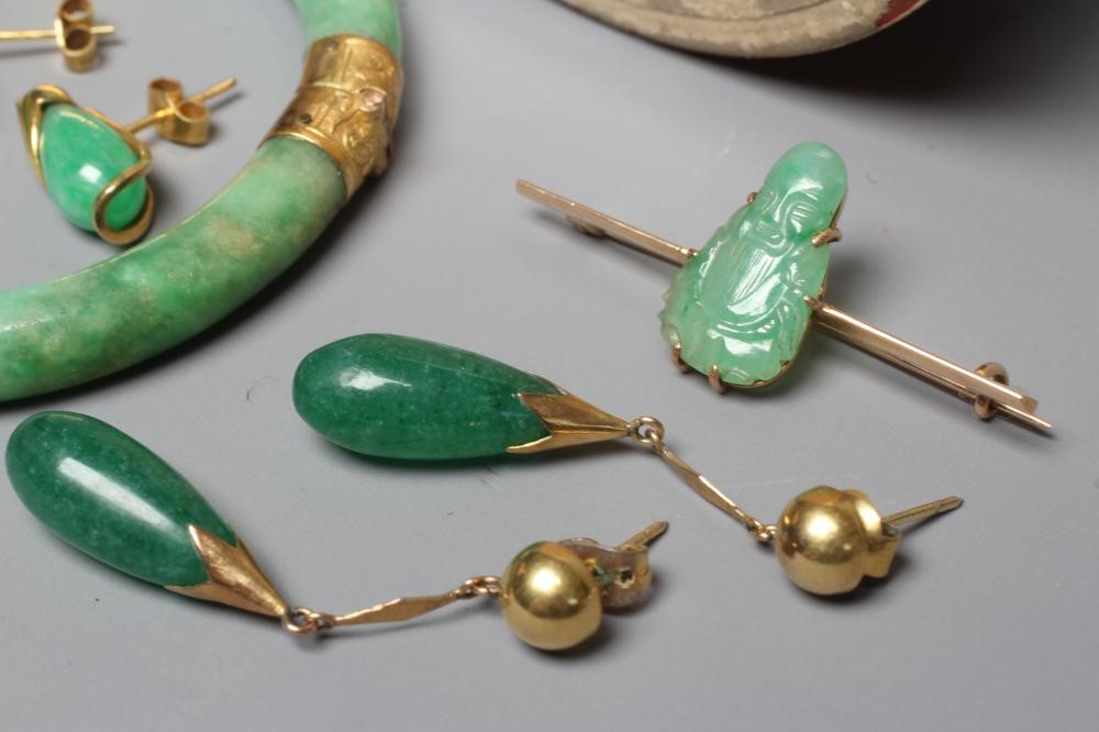 A CHINESE POLISHED JADE STIFF HINGED BANGLE of cylindrical form the chased mounts stamped 14 Image