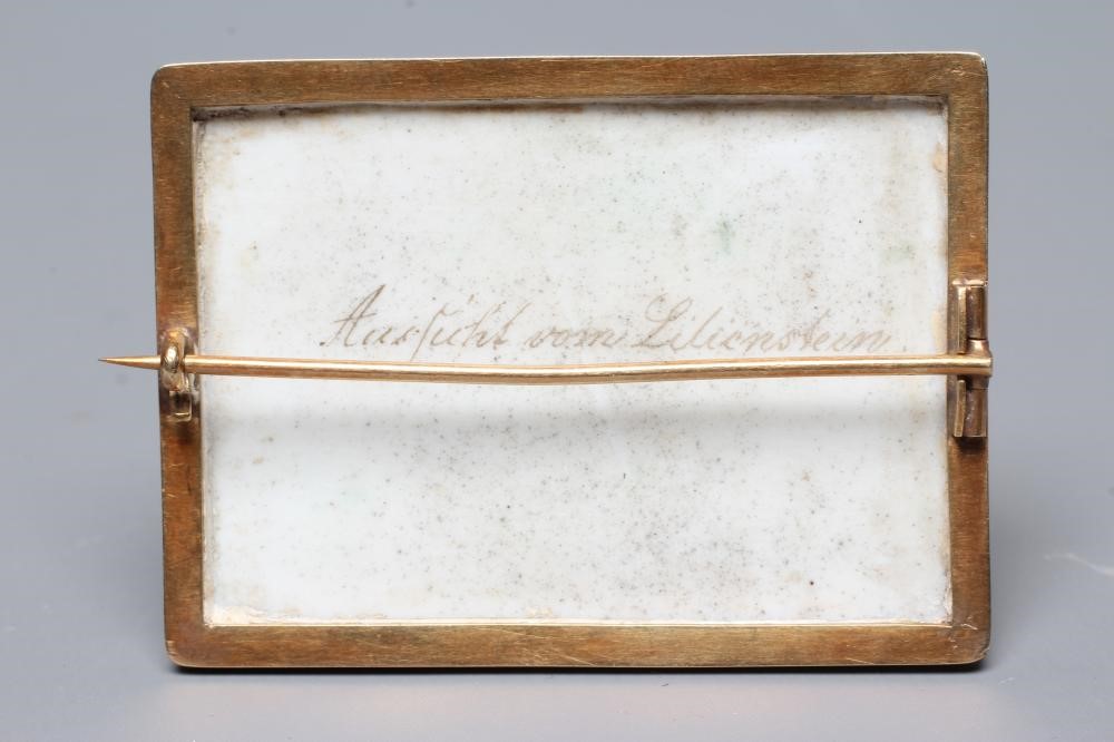 A CONTINENTAL PORCELAIN OBLONG PLAQUE BROOCH painted in polychrome enamels with an extensive lake Image