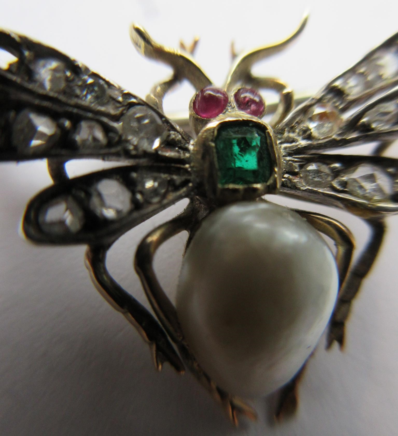 A VICTORIAN INSECT BROOCH with two ruby cabochon eyes, square cut emerald thorax and blister pearl Image