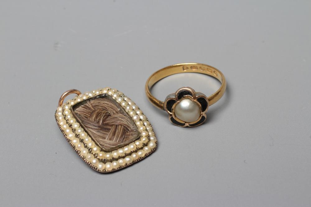 AN EARLY VICTORIAN MOURNING PENDANT of rounded oblong form with double seed pearl border enclosing a Image