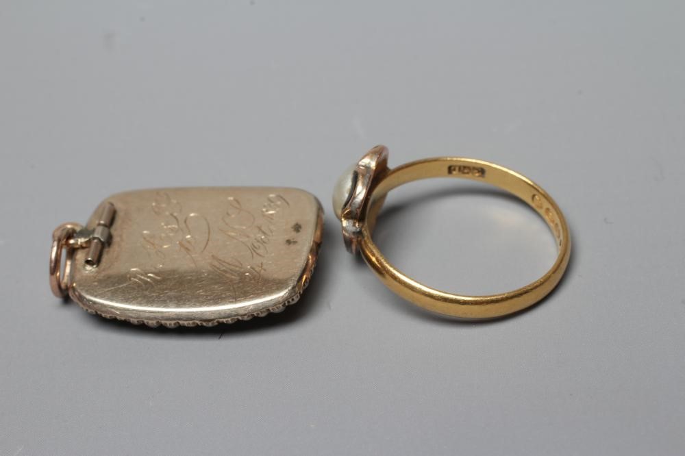 AN EARLY VICTORIAN MOURNING PENDANT of rounded oblong form with double seed pearl border enclosing a Image