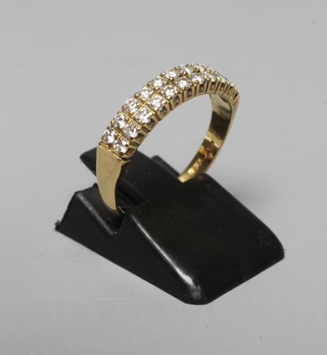 A DIAMOND HALF HOOP RING claw set with two rows of eleven small brilliant cut stones to a plain Image