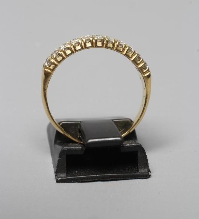 A DIAMOND HALF HOOP RING claw set with two rows of eleven small brilliant cut stones to a plain Image