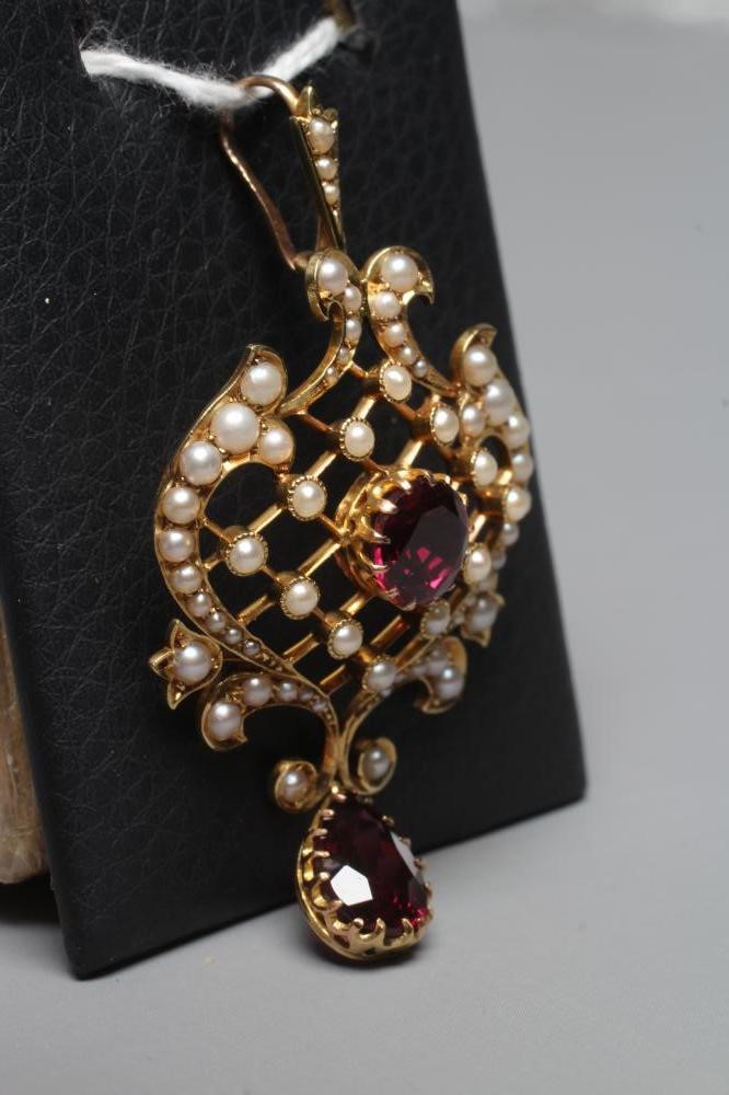 AN EDWARDIAN GARNET AND SEED PEARL PENDANT of typical shield form with knife edge diapered centre, Image