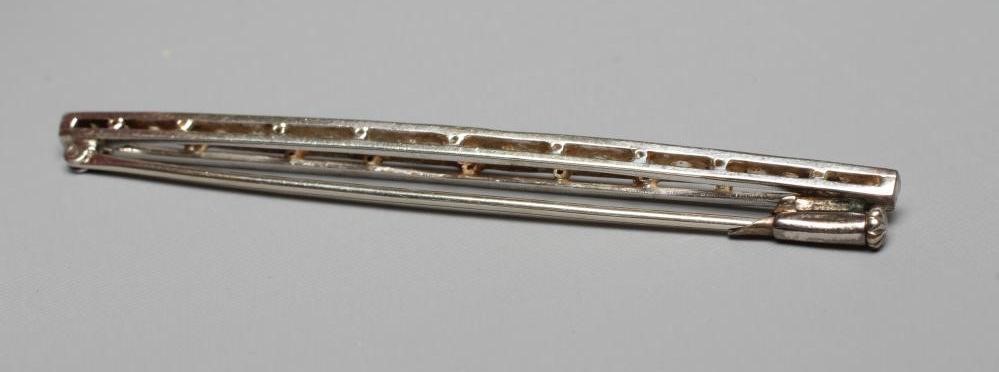 A DIAMOND BROOCH, the shaped bar point set with twenty-two old cut stones to an unmarked frame (Est. Image