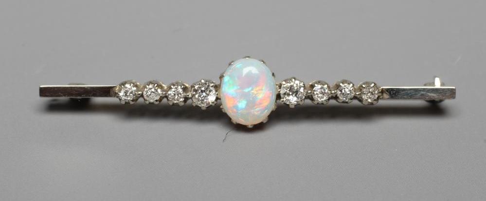 AN OPAL AND DIAMOND BAR BROOCH, the central oval cabochon polished opal claw set and with four Image