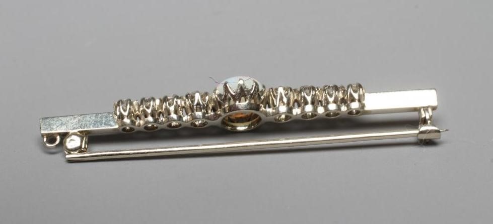 AN OPAL AND DIAMOND BAR BROOCH, the central oval cabochon polished opal claw set and with four Image