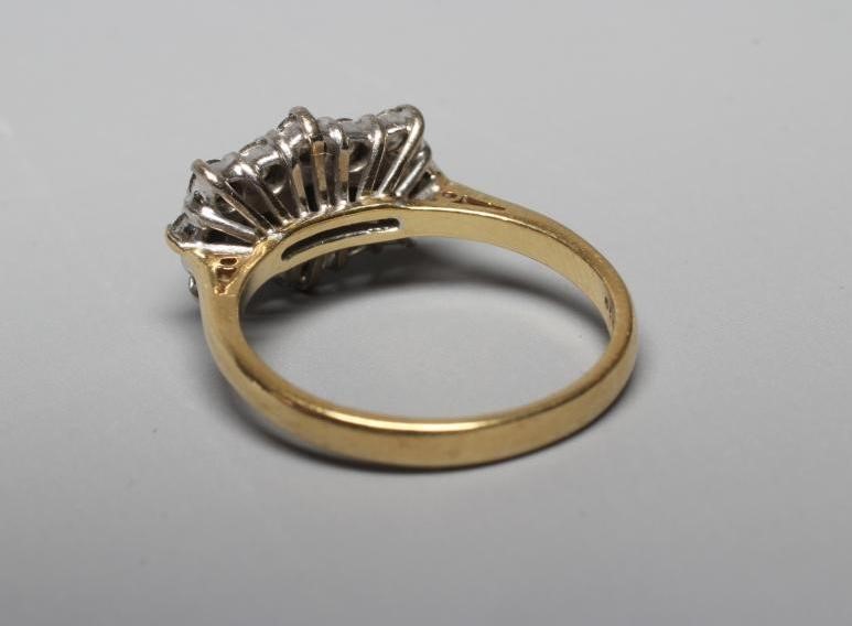 A SAPPHIRE AND DIAMOND RING, the three emerald cut sapphires claw set to a border of twelve Image