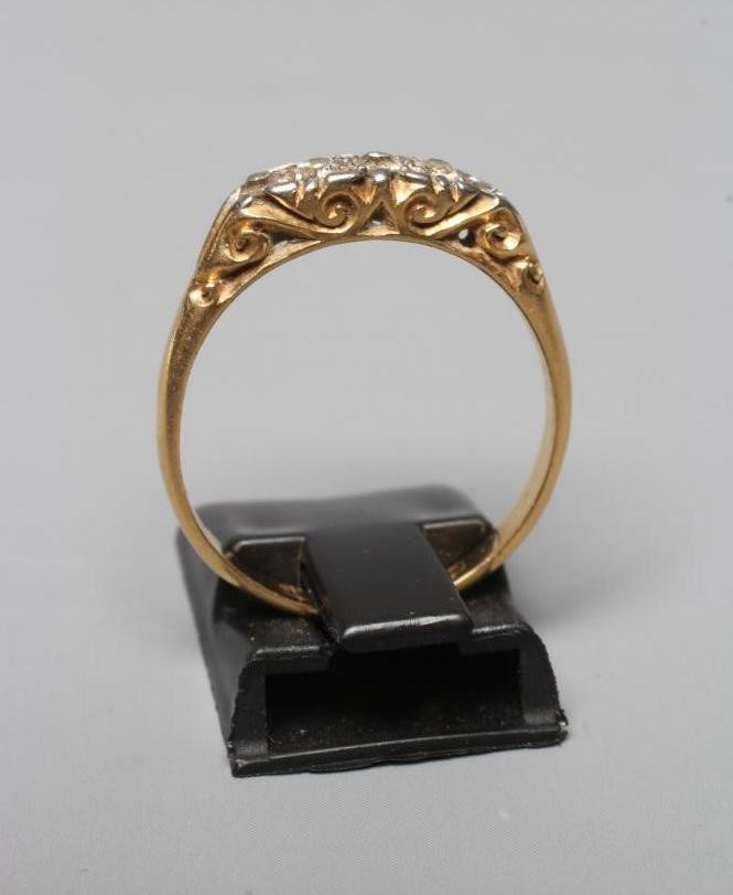 A LATE VICTORIAN FIVE STONE DIAMOND RING, the mix cut stones point set to carved mount and shoulders Image