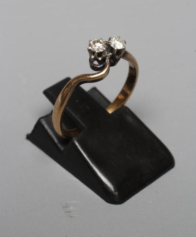 A TWO STONE DIAMOND CROSSOVER RING, the brilliant cut stones each of approximately 0.06cts, claw set Image