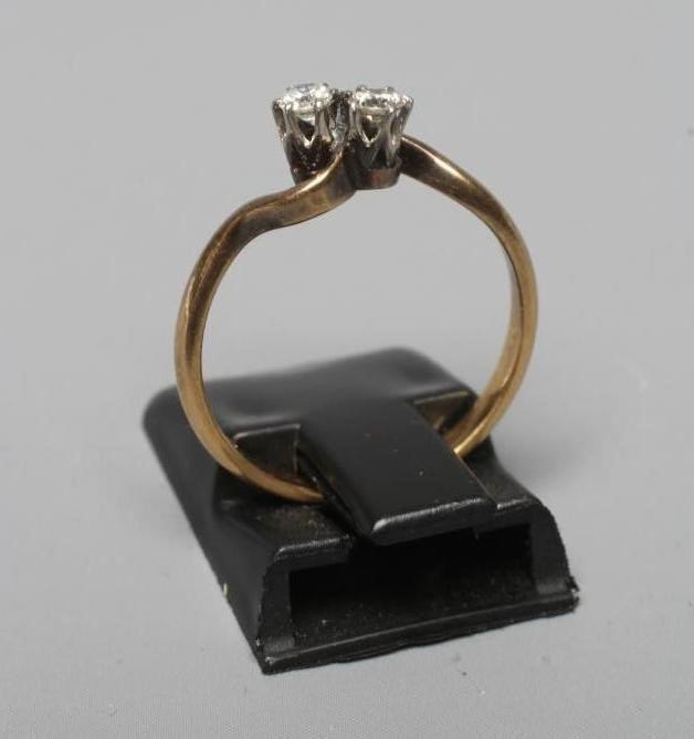 A TWO STONE DIAMOND CROSSOVER RING, the brilliant cut stones each of approximately 0.06cts, claw set Image