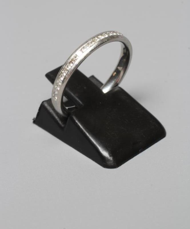 A DIAMOND HALF HOOP ETERNITY RING, the twenty seven Princess cut stones centrally channel set to a Image