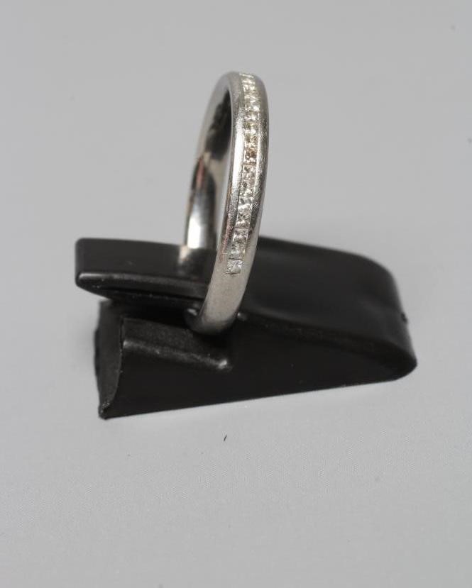 A DIAMOND HALF HOOP ETERNITY RING, the twenty seven Princess cut stones centrally channel set to a Image