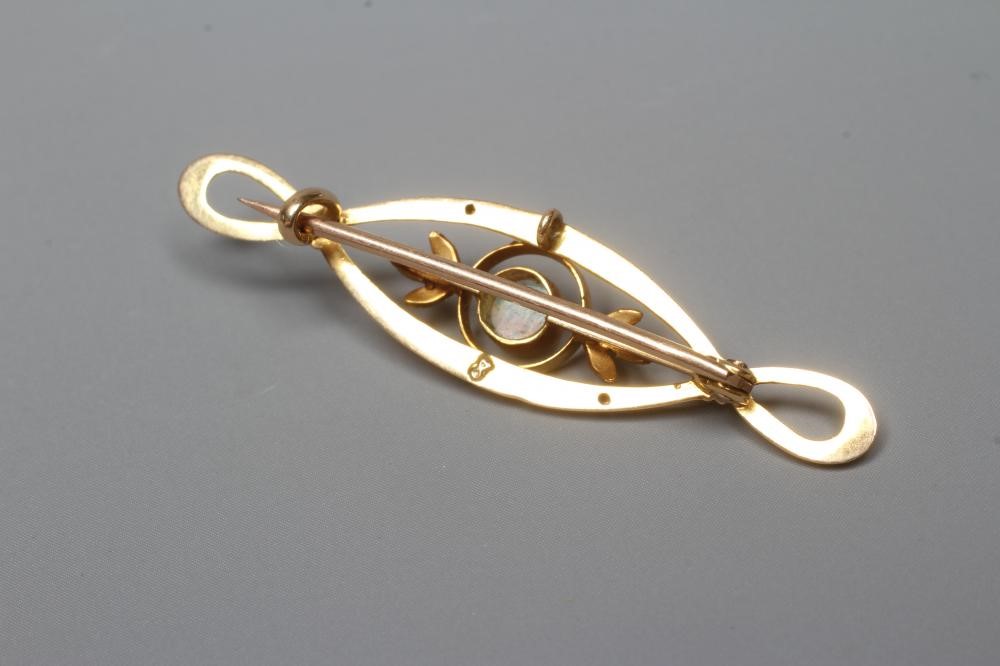 AN EDWARDIAN OPAL BROOCH, the central open oval panel collet set with an oval cabochon polished opal Image