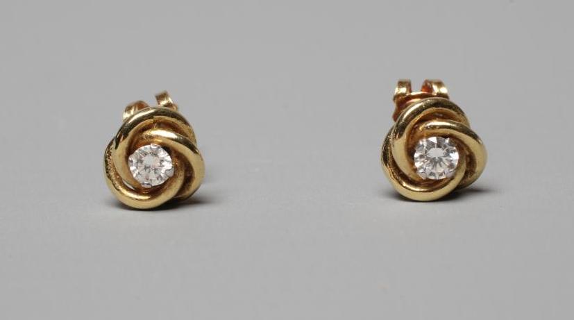 A PAIR OF SOLITAIRE DIAMOND EAR STUDS, the brilliant cut stones claw set to an 18ct gold knot (Est. Image