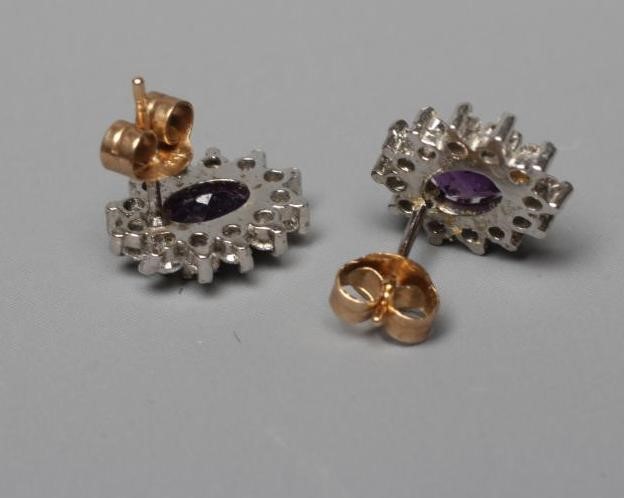 A PAIR OF AMETHYST AND DIAMOND CLUSTER EAR STUDS, the oval facet cut amethysts claw set to a border Image