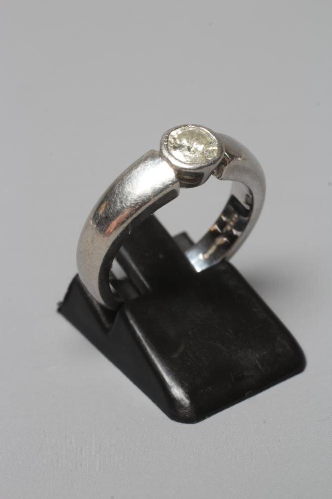 A SOLITAIRE DIAMOND RING, the brilliant cut stone of approximately 0.5cts in rub-over setting to a Image