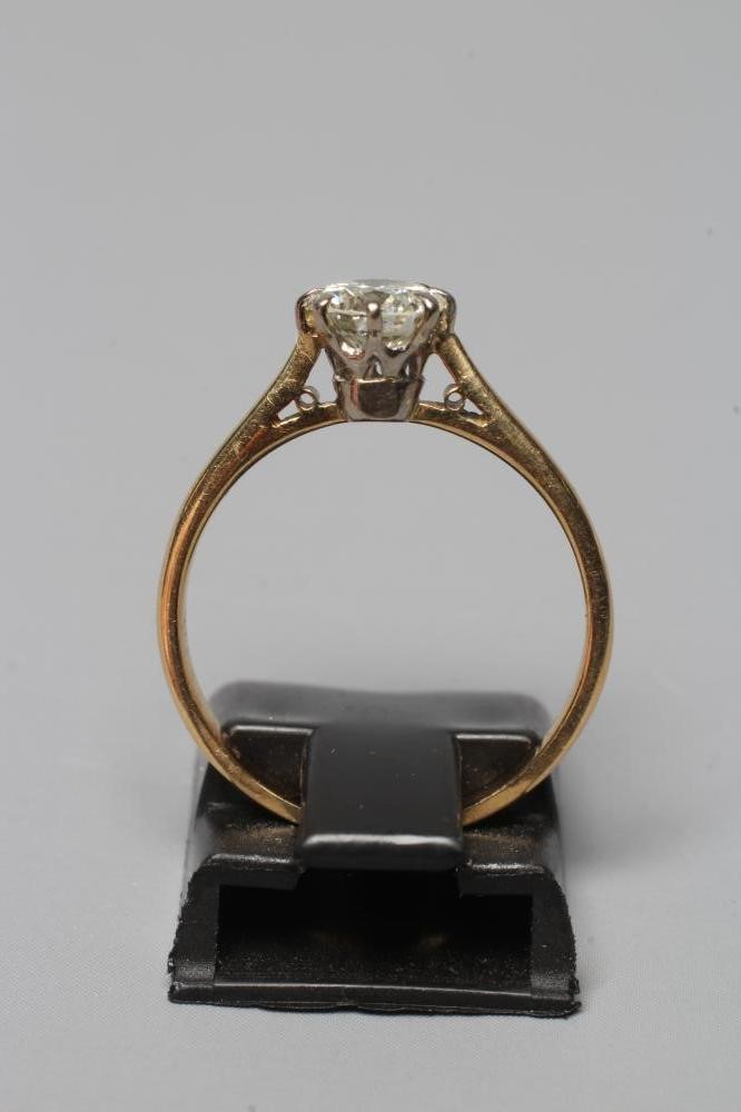 A SOLITAIRE DIAMOND RING, the brilliant cut stone of approximately 0.6cts claw set to a plain Image