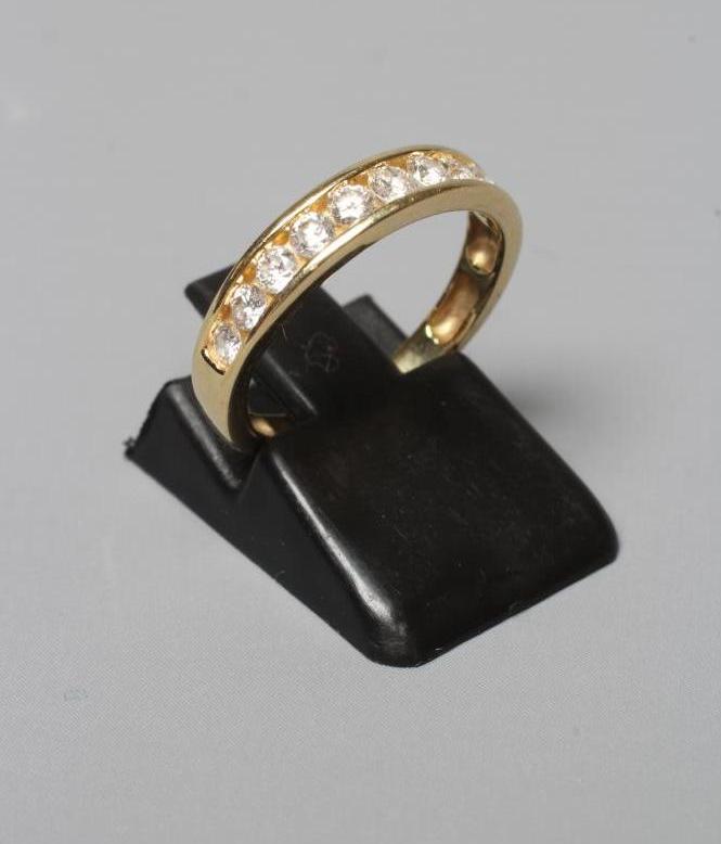 A TEN STONE DIAMOND HALF HOOP ETERNITY RING, the brilliant cut stones channel set to a plain shank Image