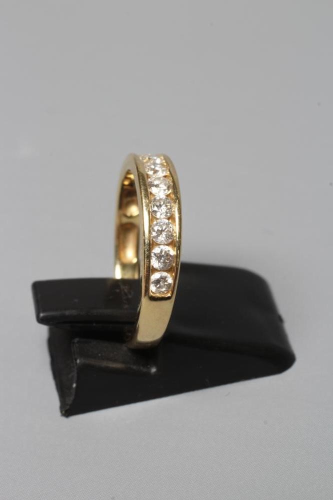 A TEN STONE DIAMOND HALF HOOP ETERNITY RING, the brilliant cut stones channel set to a plain shank Image