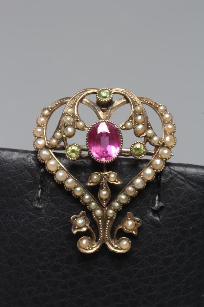 AN EDWARDIAN BROOCH/PENDANT, the open heart panel set with seed pearls and centred by an oval facet Image