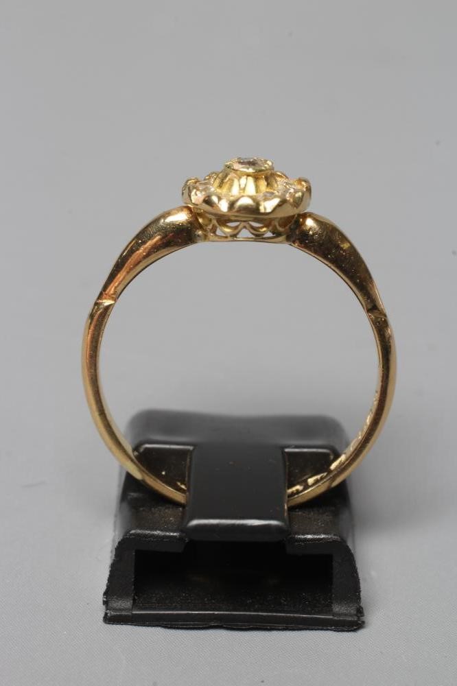 AN EDWARDIAN DIAMOND CLUSTER RING, the ten mix cut stones in rub over setting to a plain 18ct gold Image