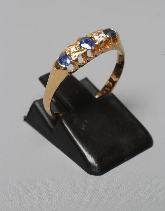 A FIVE STONE SAPPHIRE AND DIAMOND RING, the three facet cut sapphires and two diamonds claw set to a Image