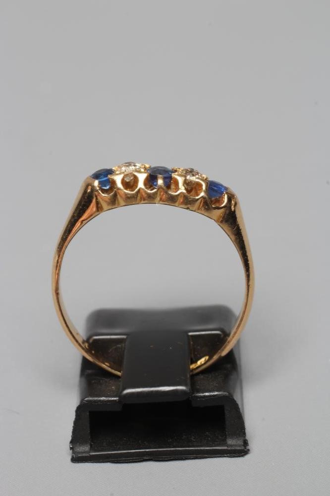 A FIVE STONE SAPPHIRE AND DIAMOND RING, the three facet cut sapphires and two diamonds claw set to a Image