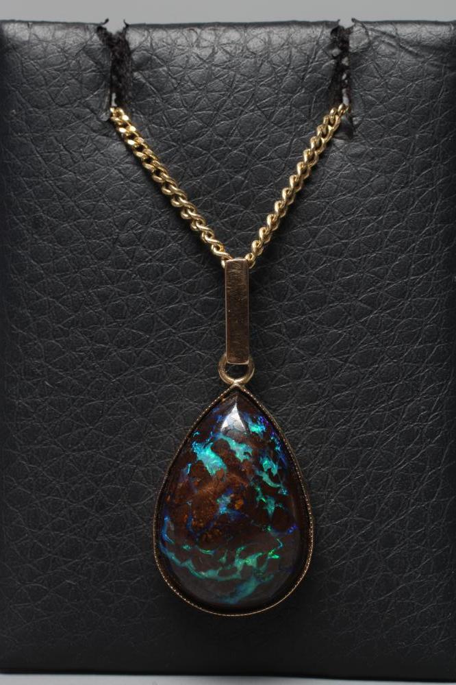 AN OPAL PENDANT, the pear cut cabochon 'boulder' stone in a plain close back mount with plain bale, Image