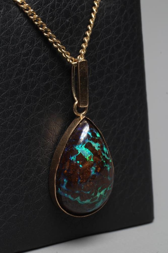 AN OPAL PENDANT, the pear cut cabochon 'boulder' stone in a plain close back mount with plain bale, Image