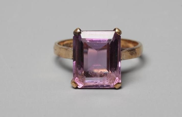 AN AMETHYST DRESS RING, the oblong facet cut stone claw set to a plain 9ct gold shank, Birmingham Image