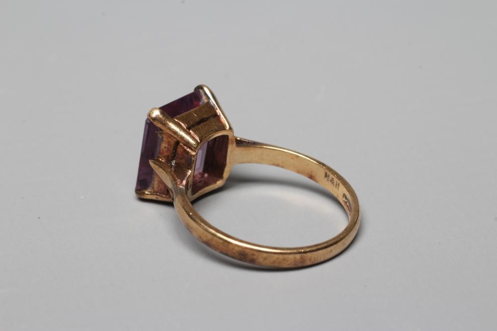 AN AMETHYST DRESS RING, the oblong facet cut stone claw set to a plain 9ct gold shank, Birmingham Image