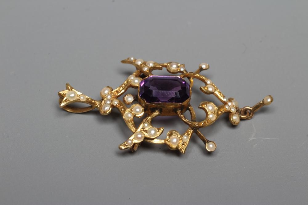 AN EDWARDIAN AMETHYST AND SEED PEARL PENDANT of typical open shield form centred by a step cut Image