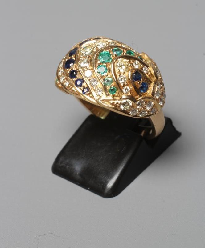A MULTI-GEM COCKTAIL RING, the oval panelled boss set with rows of diamonds, emeralds and sapphires Image